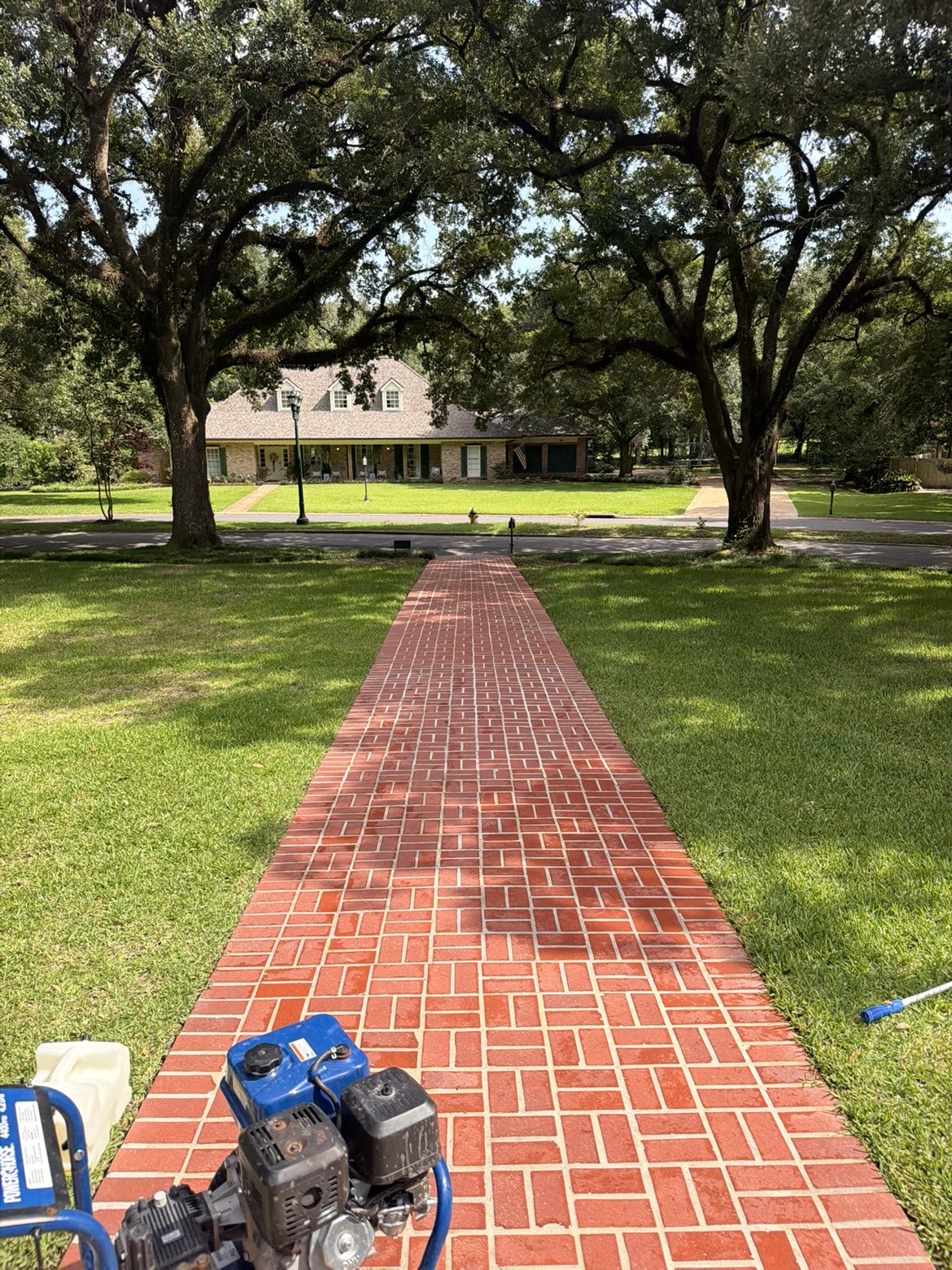 Same brick walkway restored to bright red after pressure washing